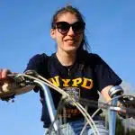 woman in black and yellow crew neck t-shirt riding bicycle during daytime