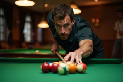 Joueur de billard positionnant les boules sur un tapis vert en vue de préparer un break stratégique