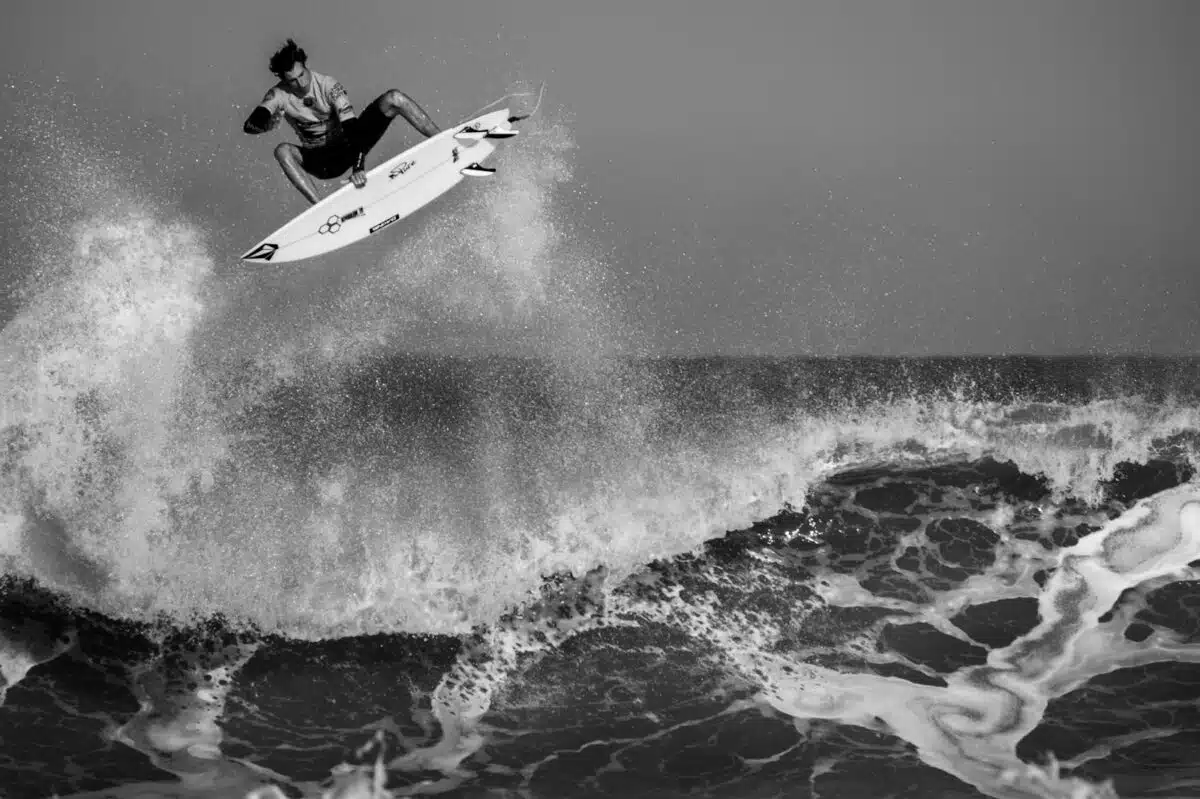 grayscale man surfing