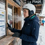 Skieuse consultant les tarifs des forfaits courts séjours à La Plagne au guichet de la station