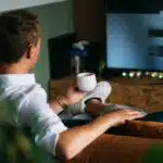 man in white dress shirt holding white ceramic mug